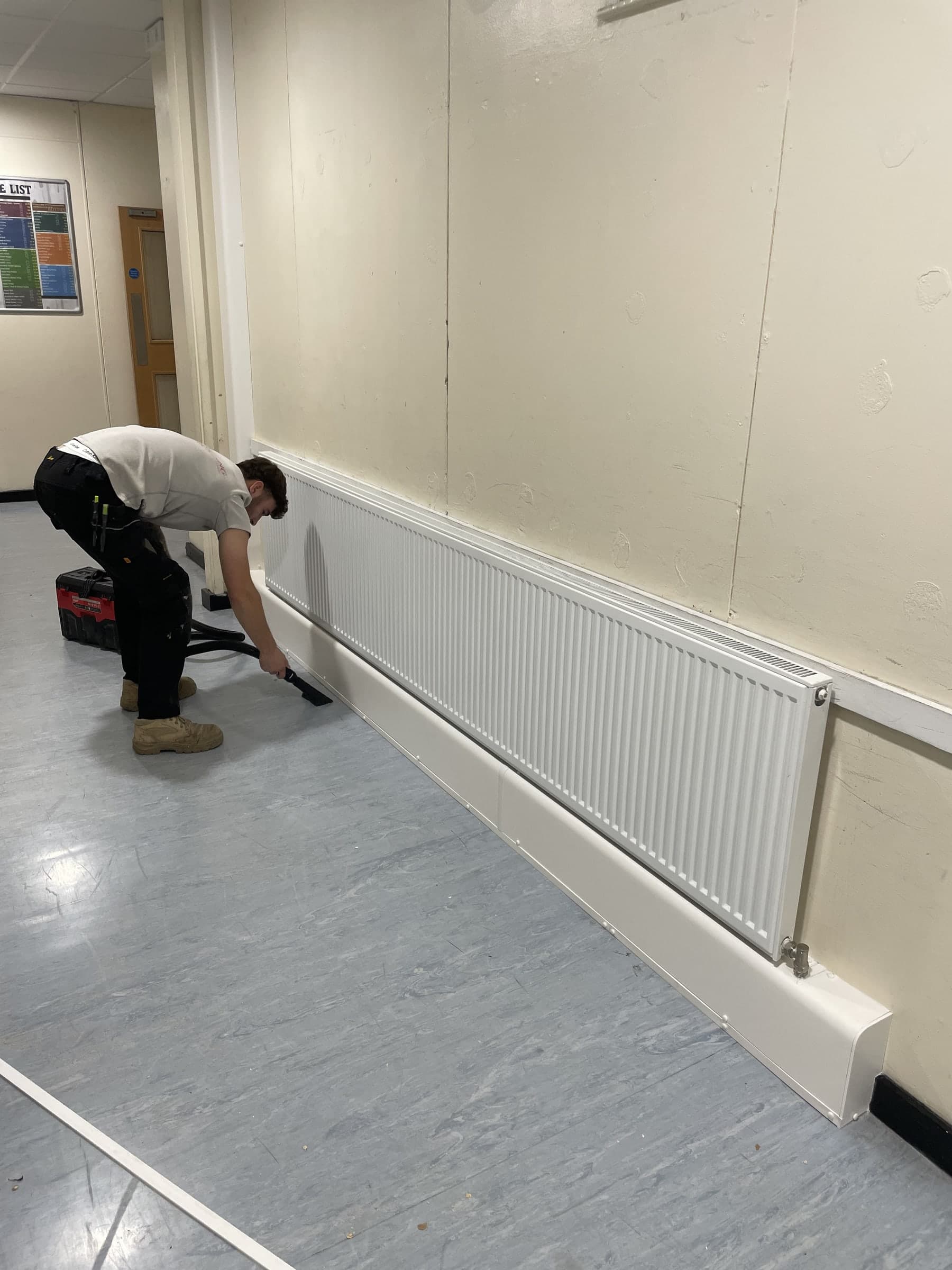 Commercial pipe encasement being cleaned down beside the radiator