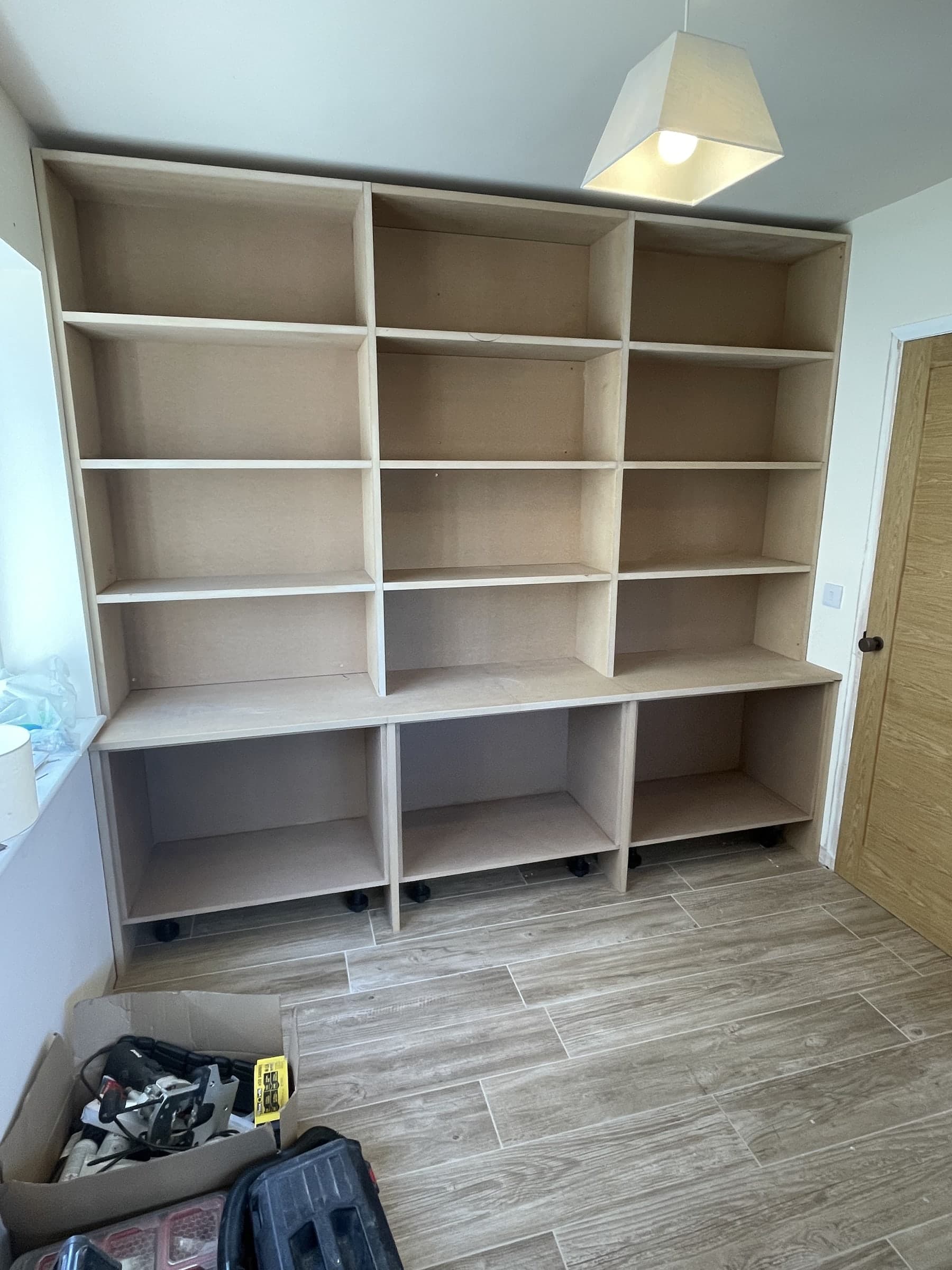 Completed bespoke shelving wall with fitted storage