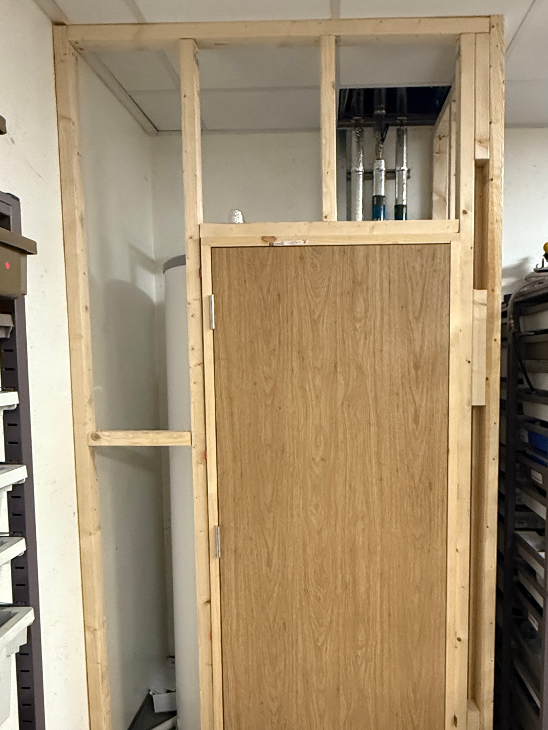 Commercial oak door installation progress with surrounding frame