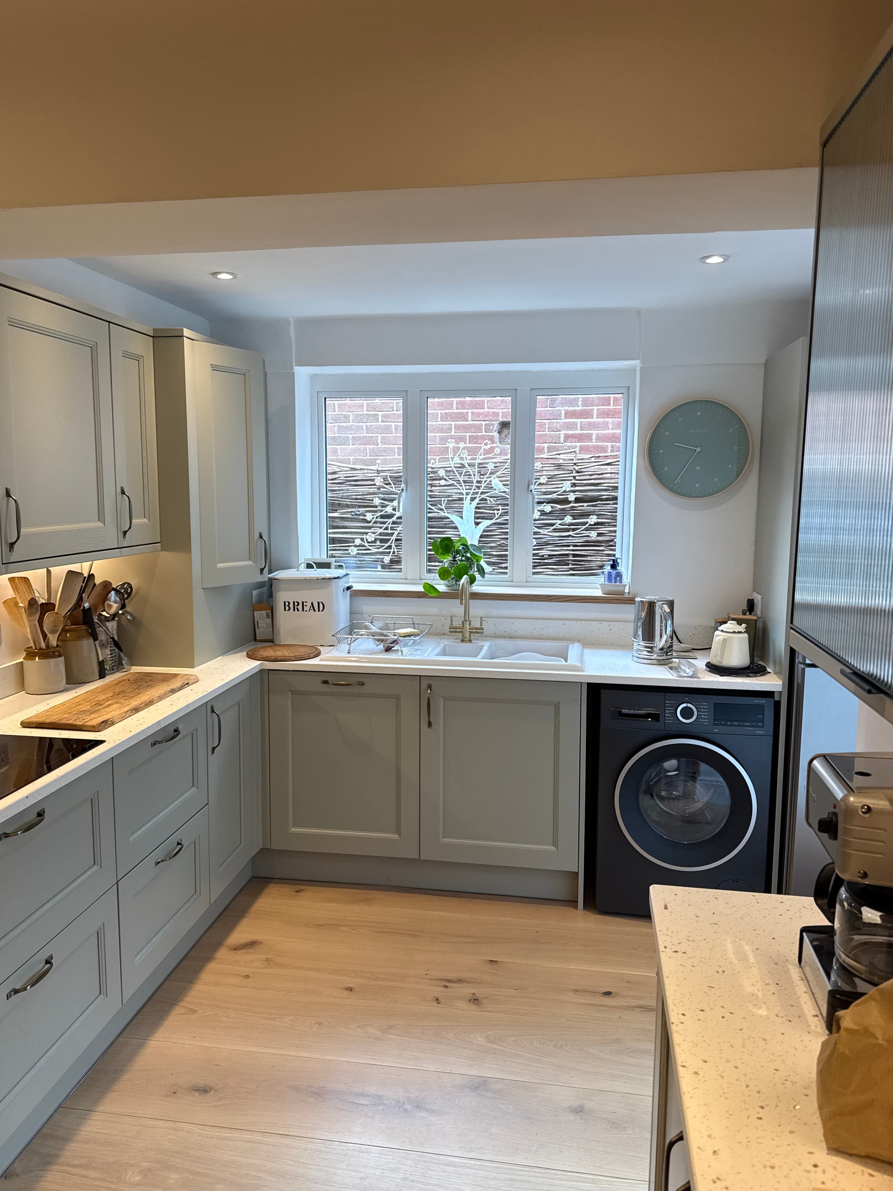 Finished kitchen sink wall with worktop, washer and fitted units
