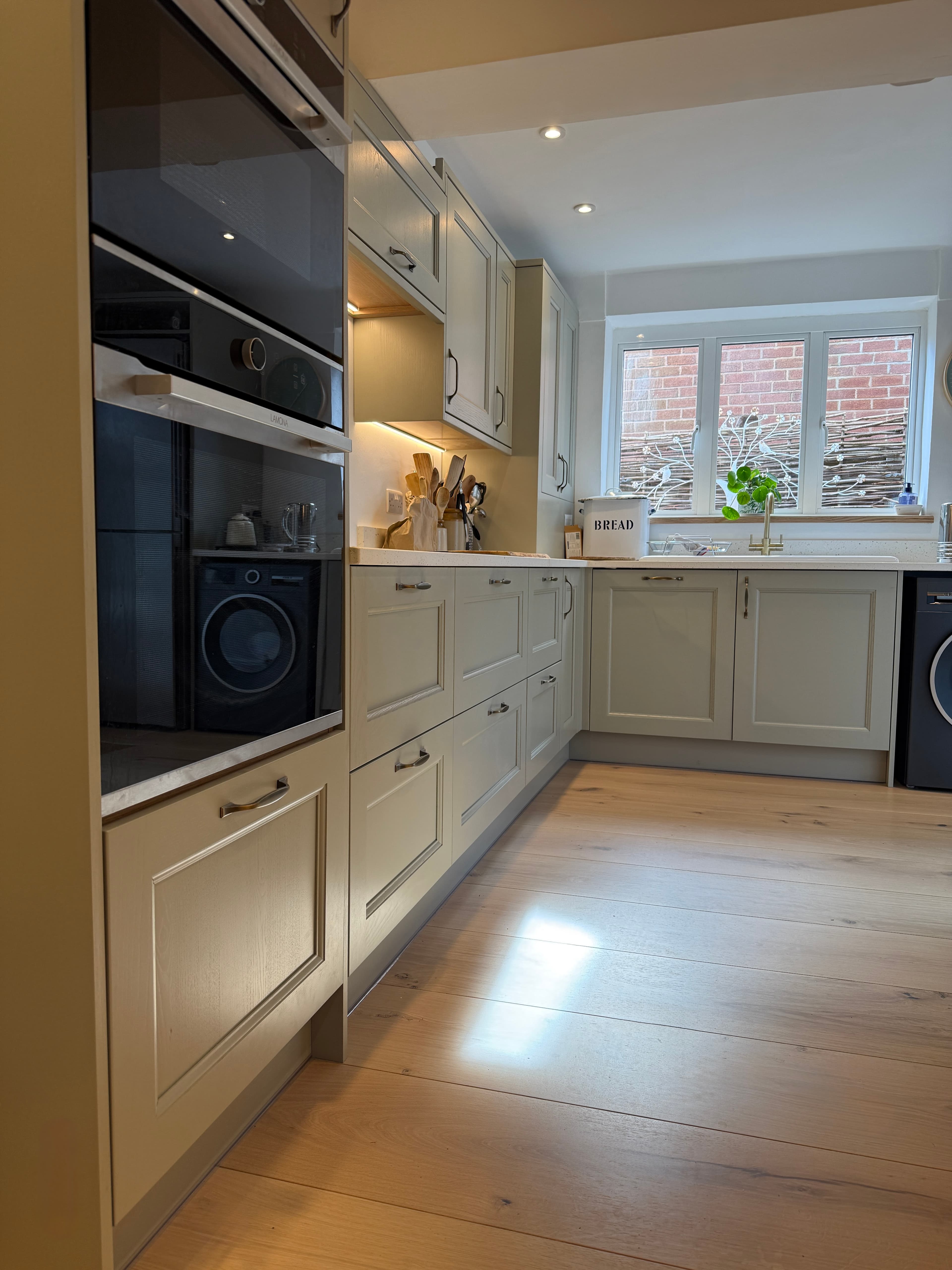 Finished sage green kitchen viewed from the oven run