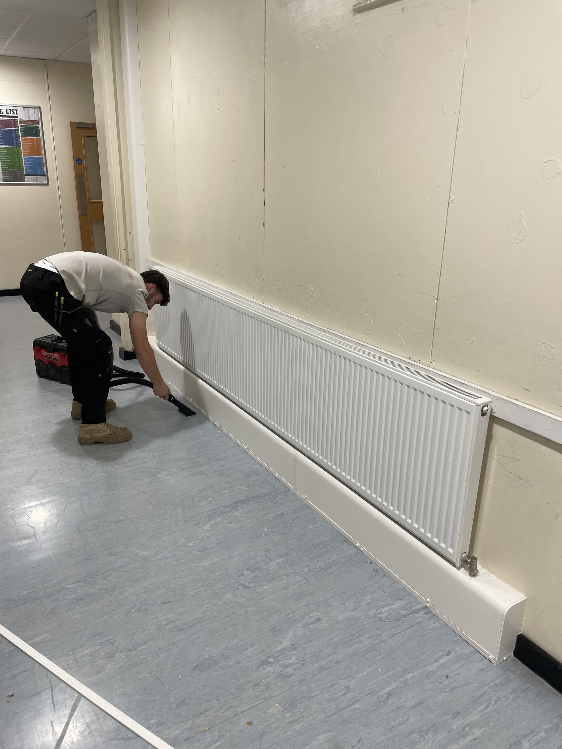 Commercial pipe encasement being cleaned down beside the radiator
