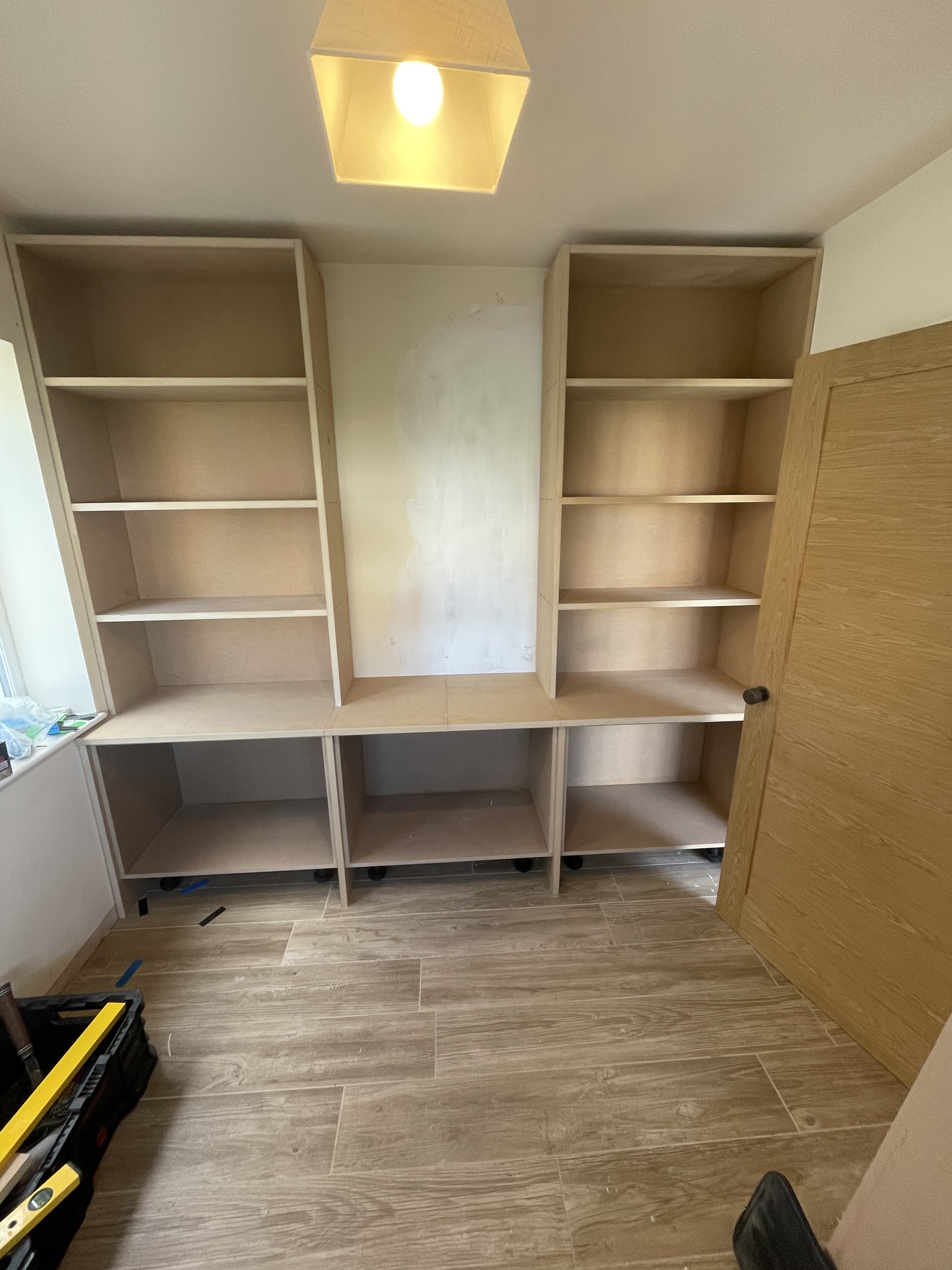 Bespoke shelving wall installation progress photo 1