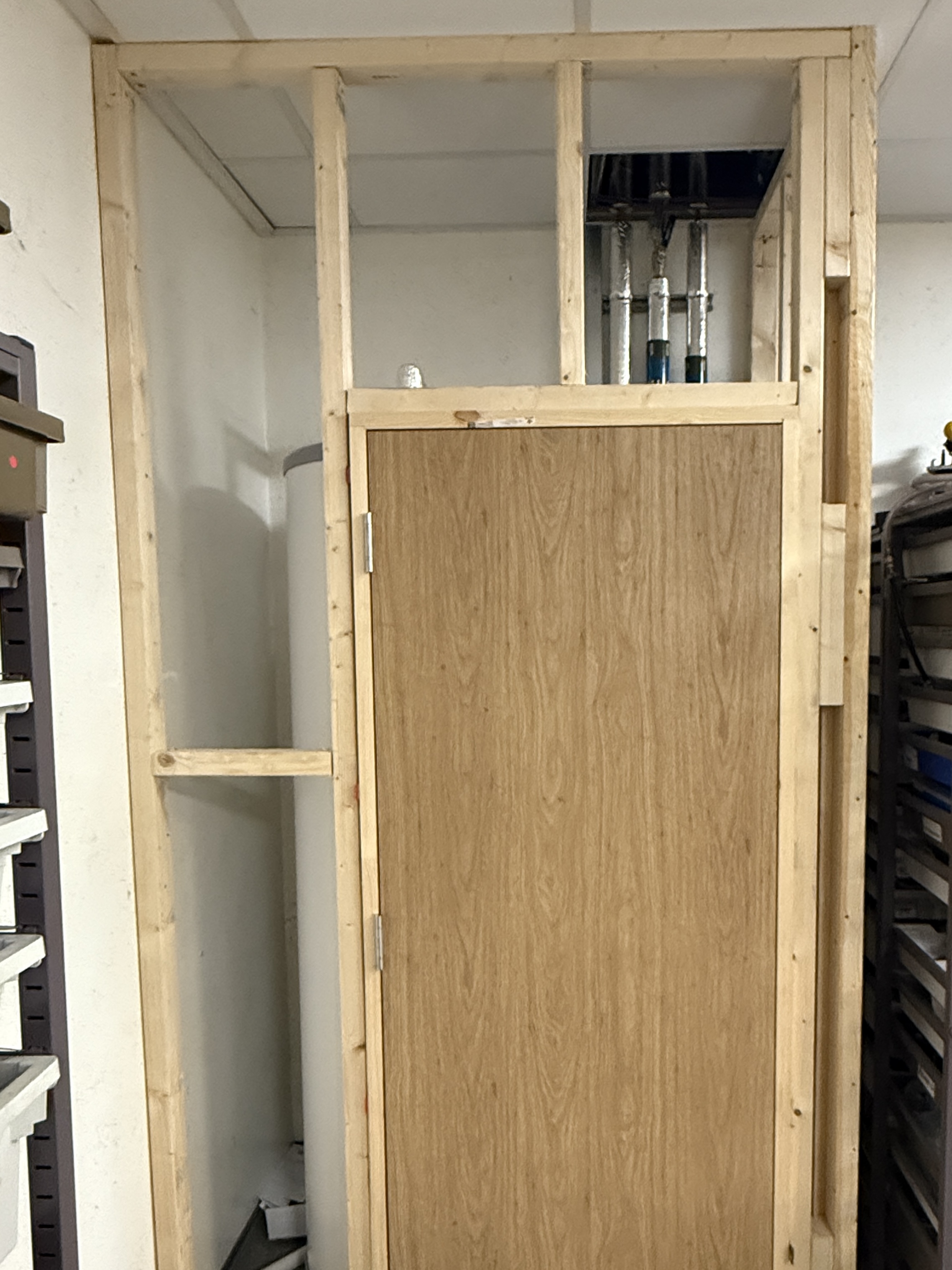 Commercial oak door installation progress with surrounding frame