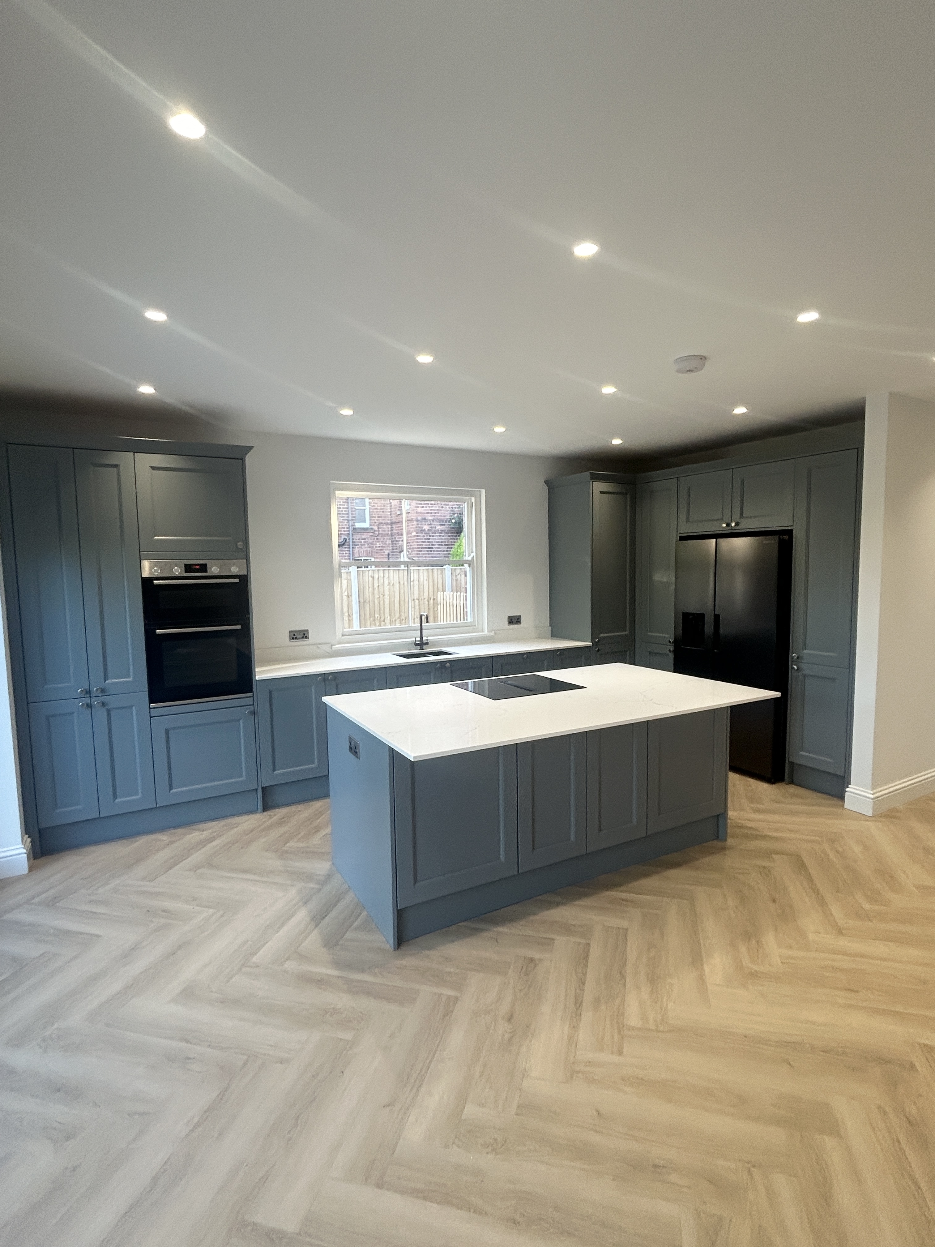 Finished open-plan kitchen renovation with grey shaker units and island