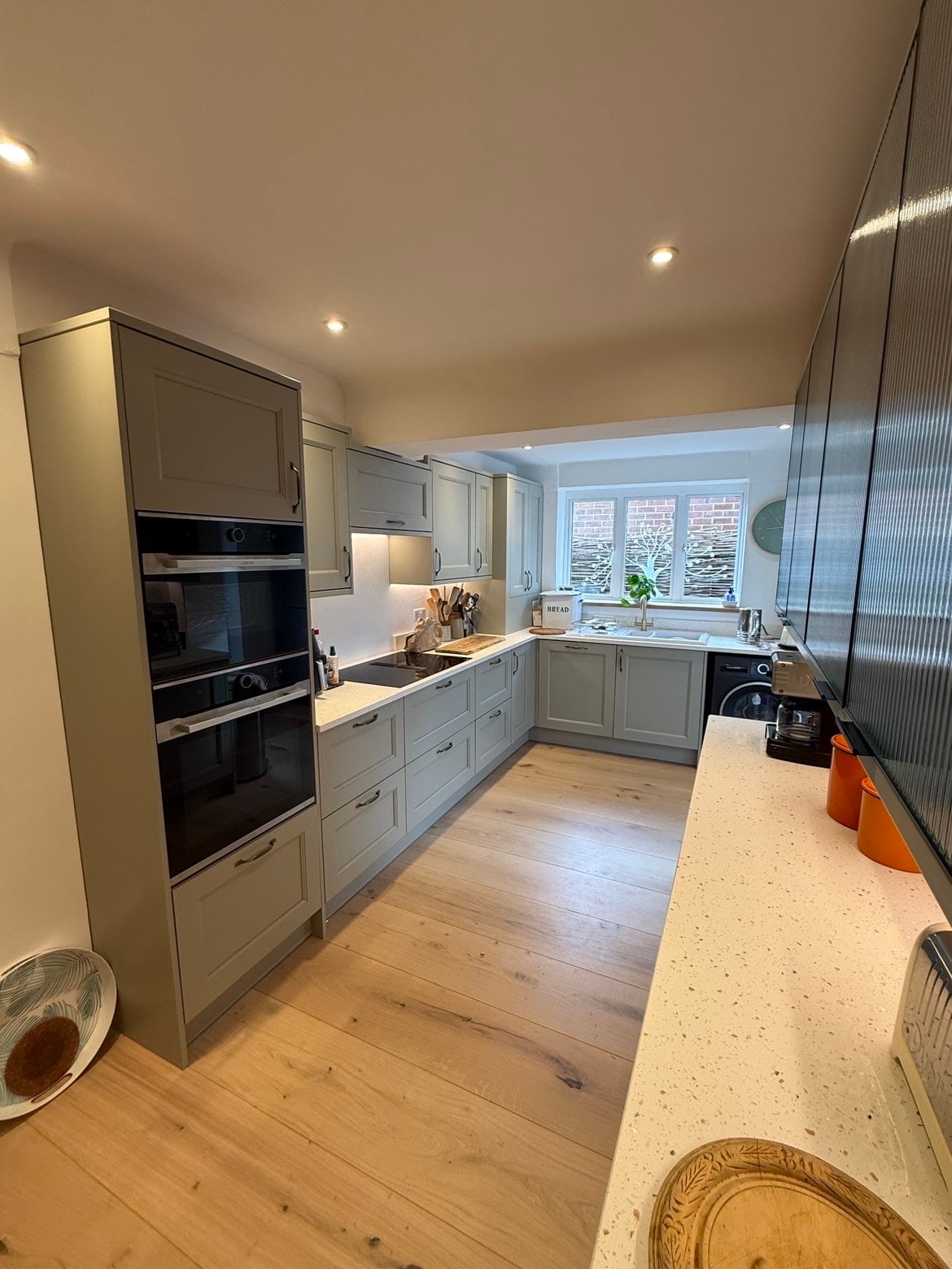Completed sage green shaker kitchen renovation with fitted units, worktops and lighting
