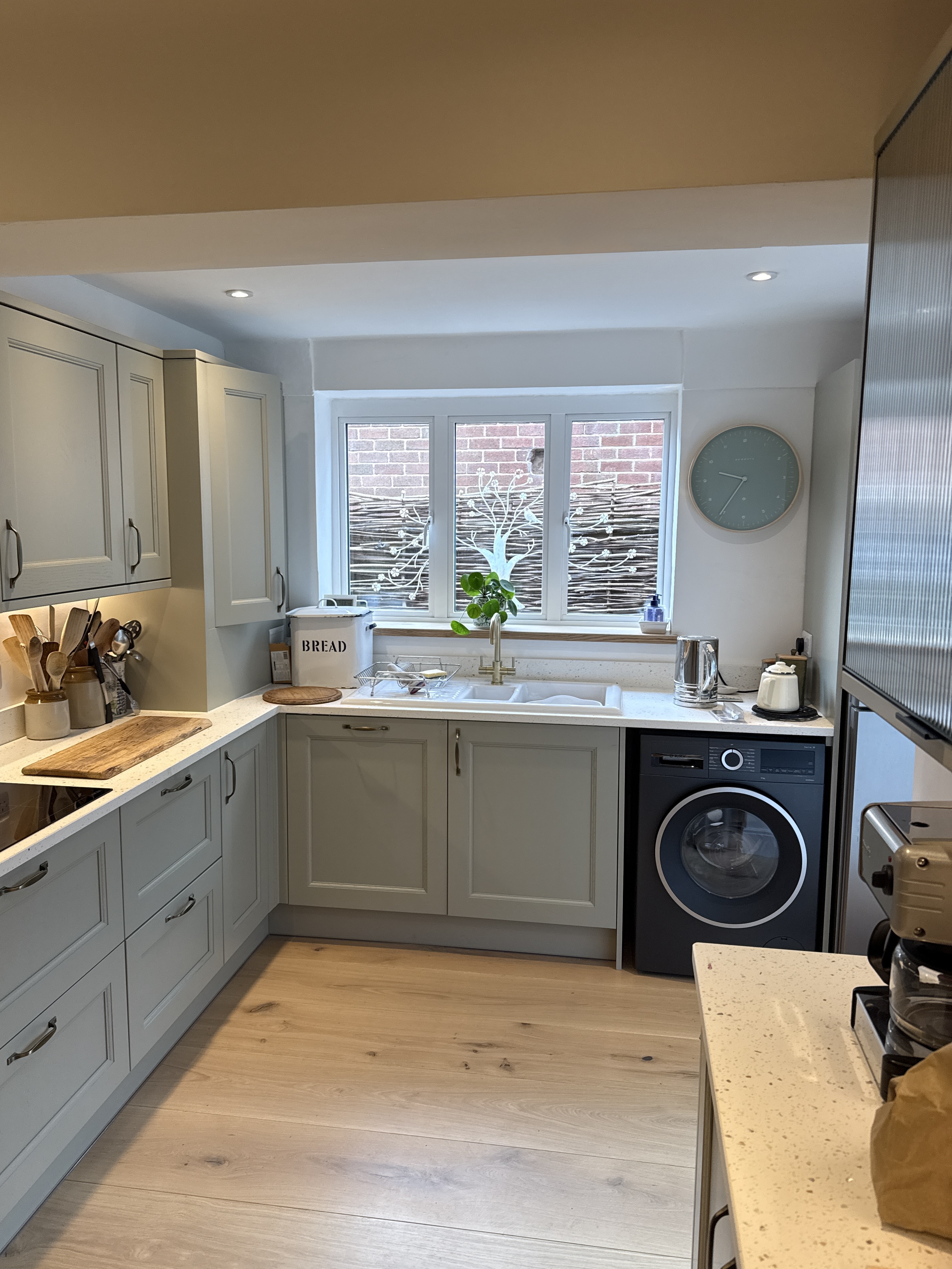 Finished kitchen sink wall with worktop, washer and fitted units