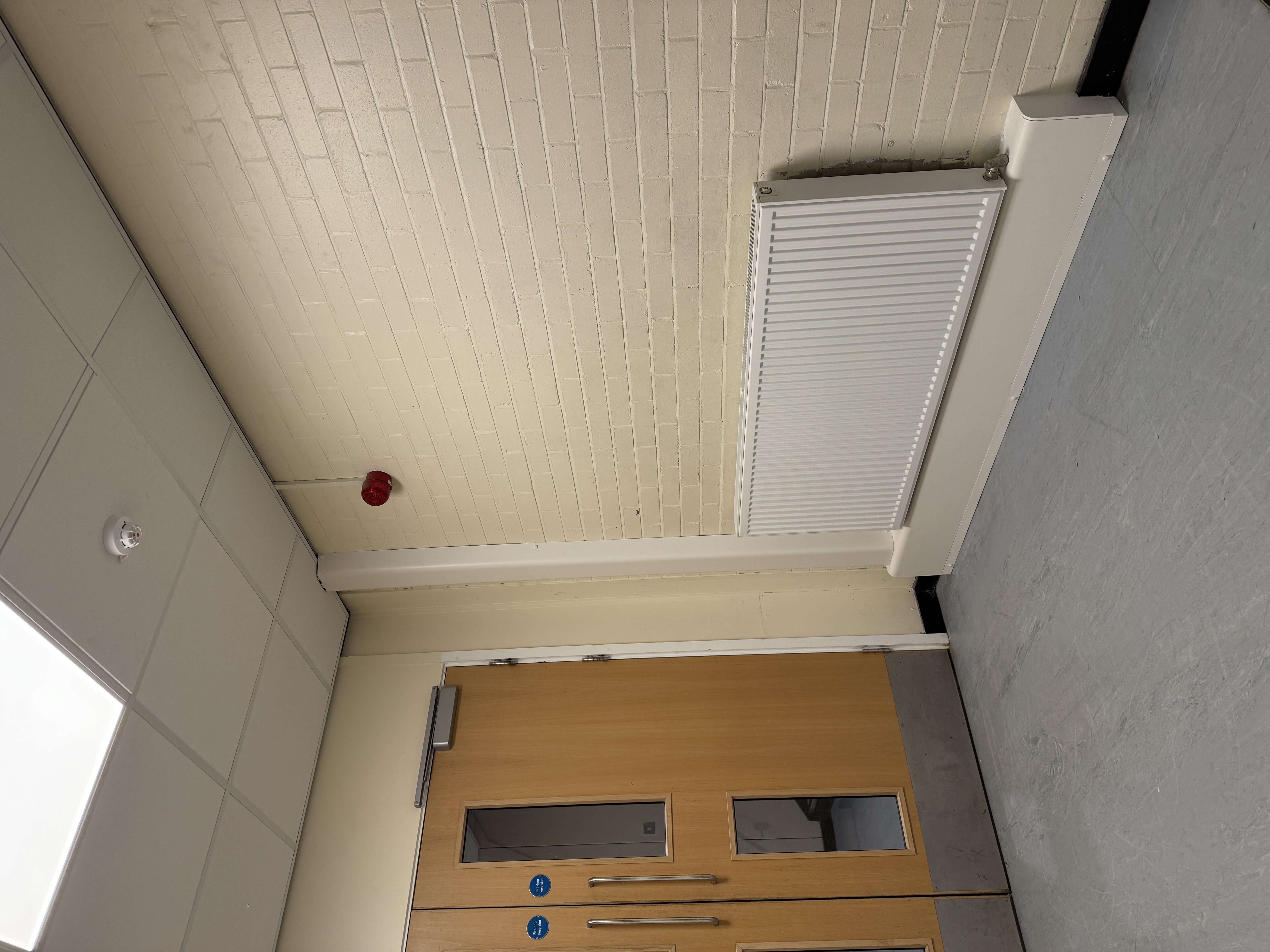 Commercial pipe encasement detail below a corridor radiator